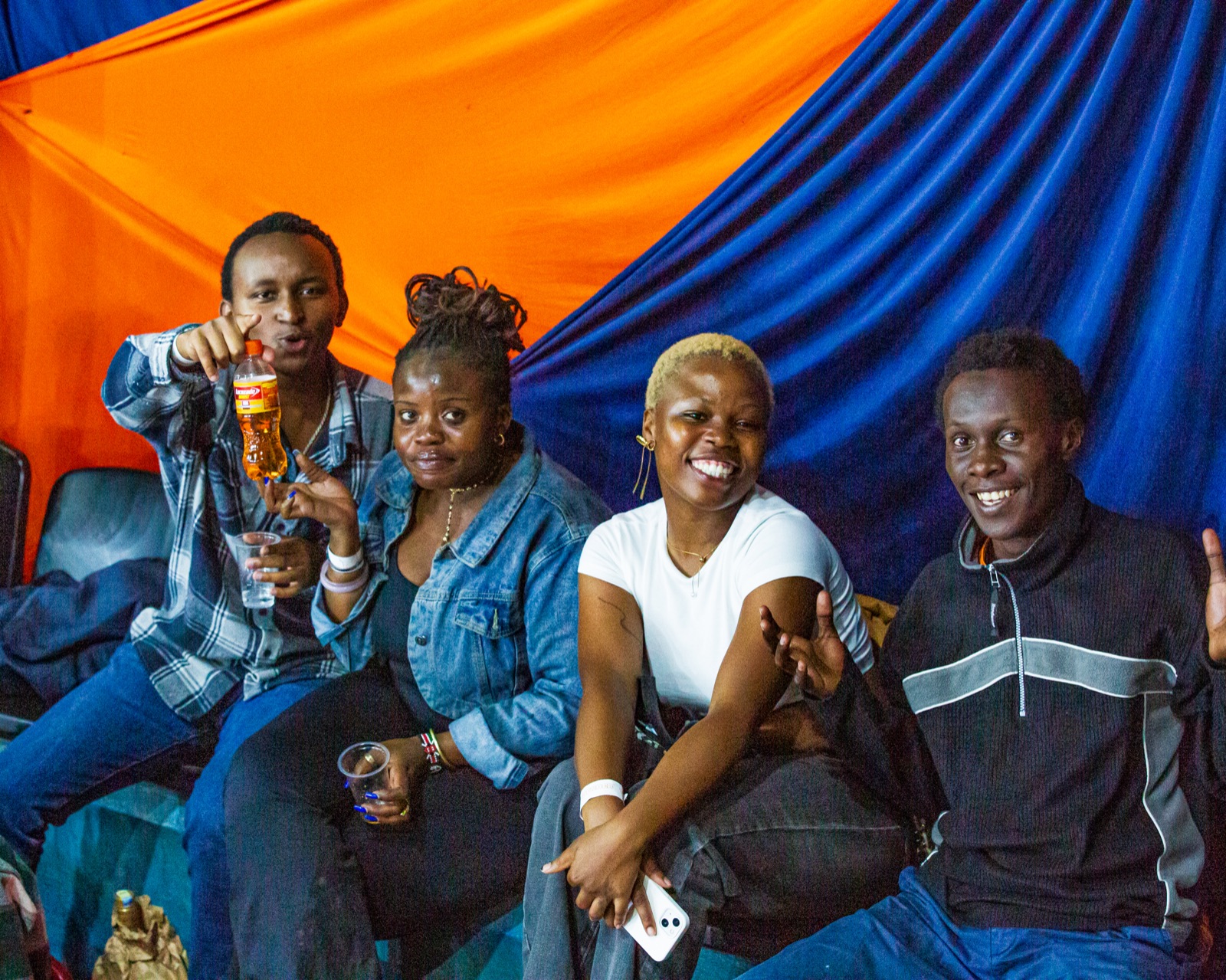 Friends gathered under orange and blue drapes at a Umoja game