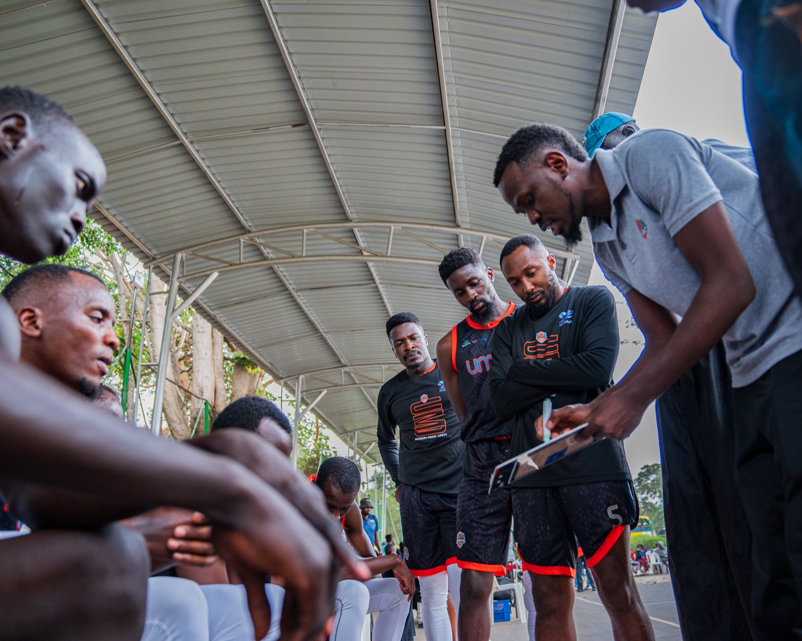 Umoja Basketball players and coaches in a team huddle
