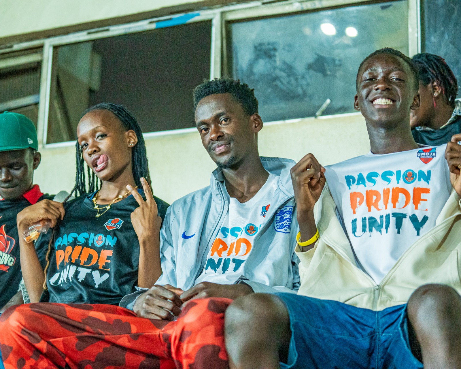 Young Umoja supporters in club colors smiling from the stands